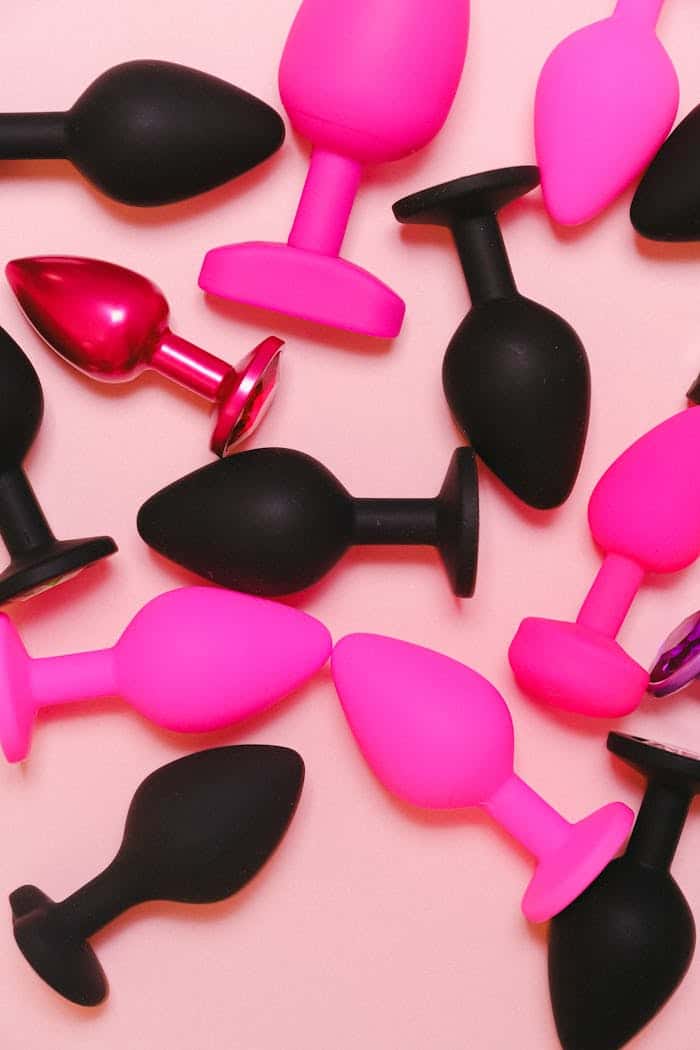 gallery-03 Bright and colorful collection of silicone adult toys on a pastel pink background.